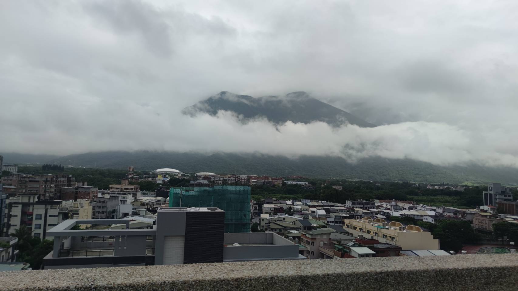 雲霧橫掛山腰,城市就在前景