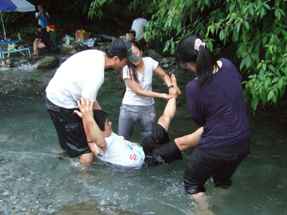 學生在溪流中把老師放水流的照片