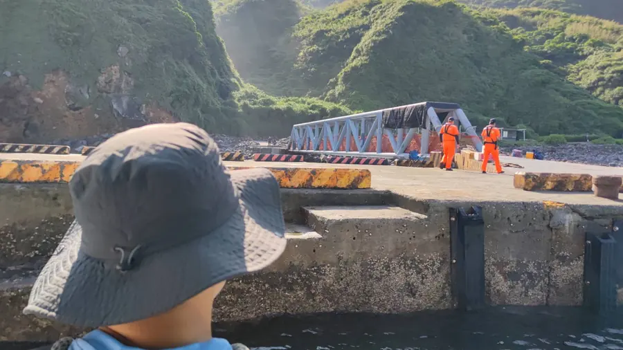 準備靠岸。岸上的工作人員已經就位,登島通道就在前方。
