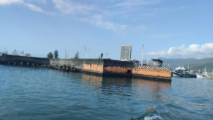 船才剛離港,防波堤上已經有人在釣魚。