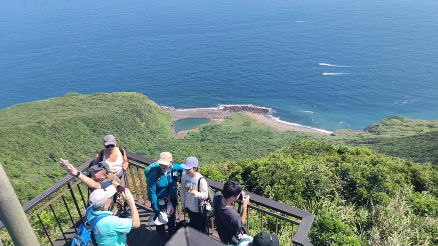 山頂觀景平台,人們在風景前拍照、休息。