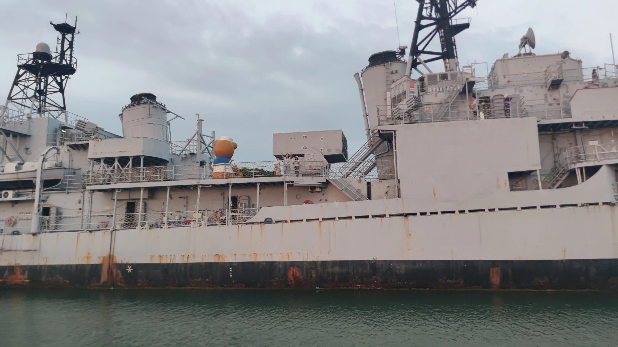德陽艦甲板上有遊客舉手向遊艇方向揮手