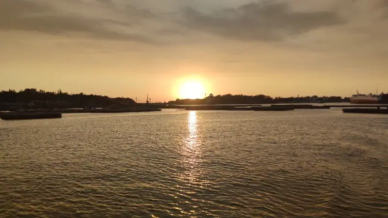 夕陽接近安平岸線，金色倒影延伸在港面上