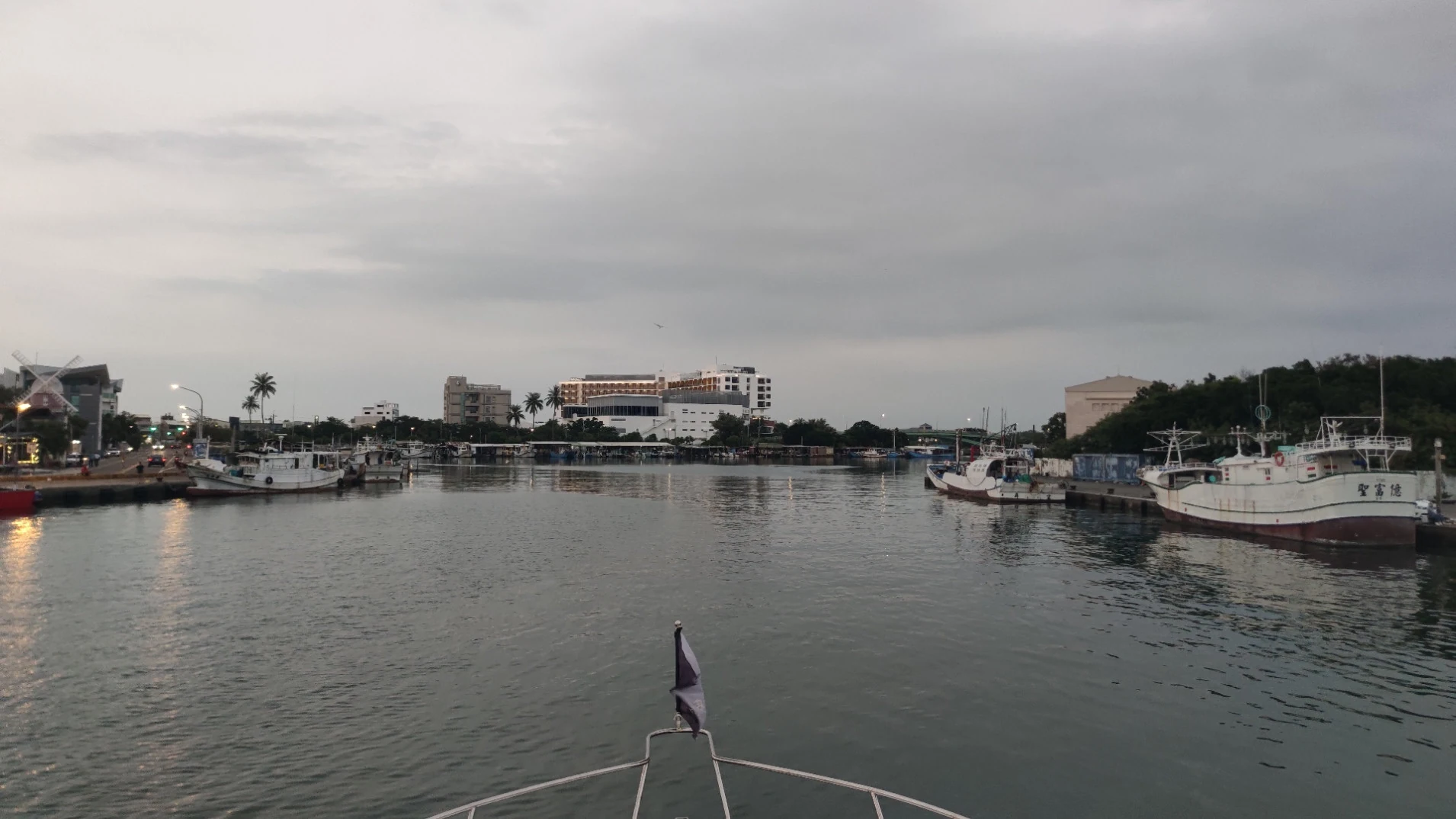 返航時從遊艇船首看港內水道，遠方飯店與兩岸漁船映入眼簾
