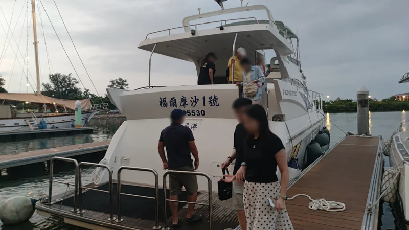 停靠碼頭的福爾摩沙一號，乘客從船尾回到碼頭，人物臉部已模糊處理。